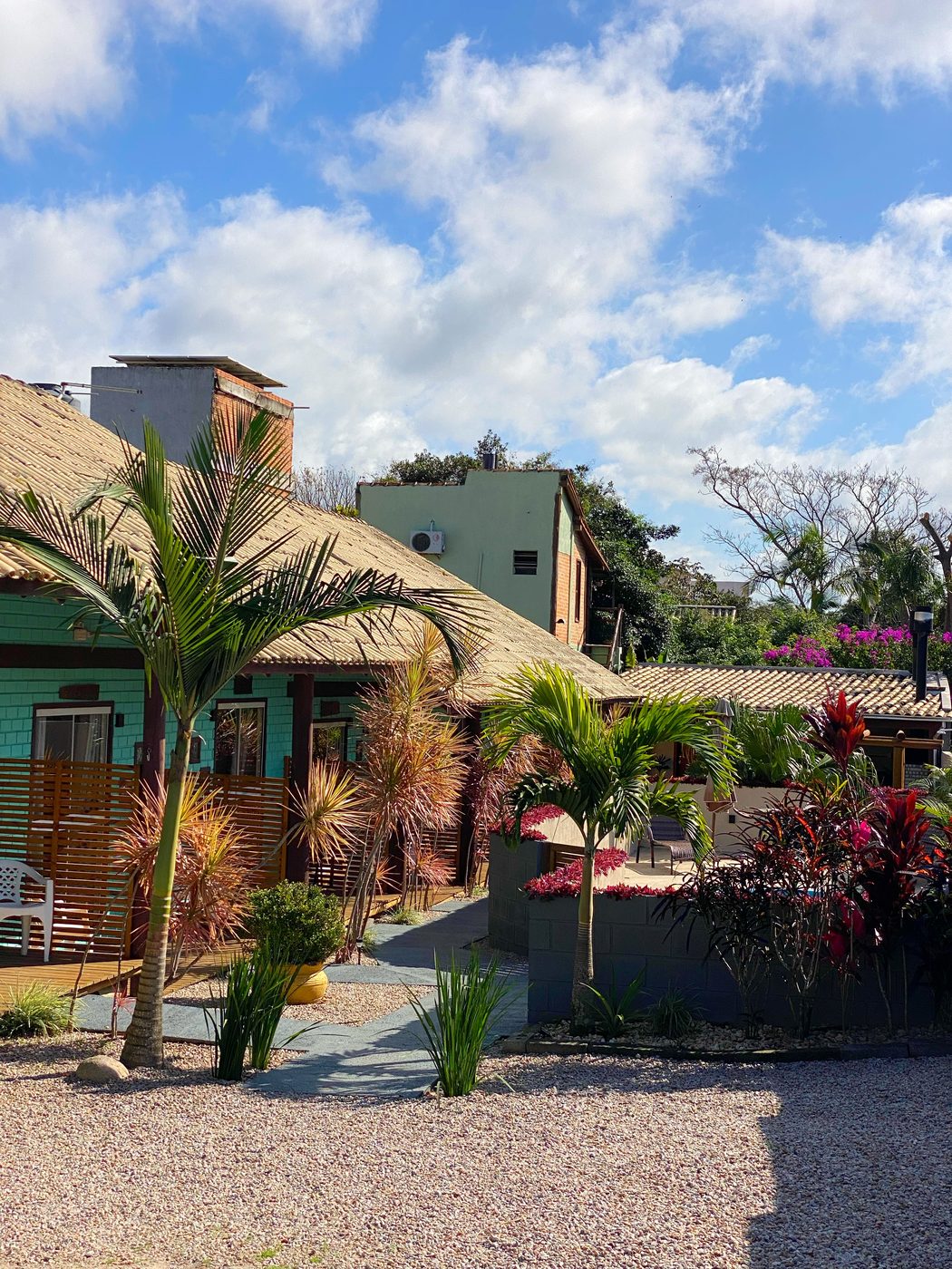 Fachada da Pousada Hanalie com coqueiros, no centrinho da Praia do Rosa
