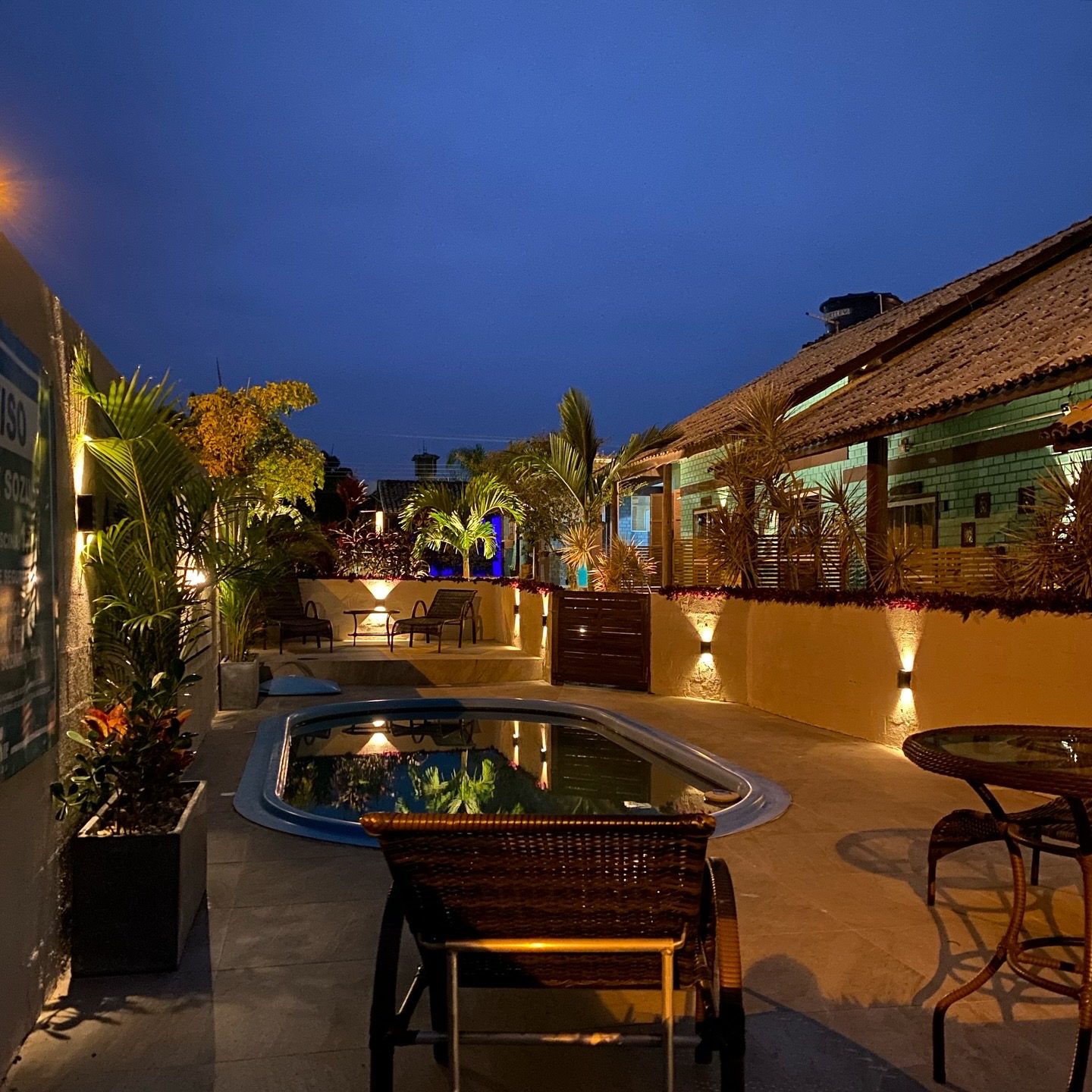 Piscina e área externa da Pousada Hanalie ao entardecer